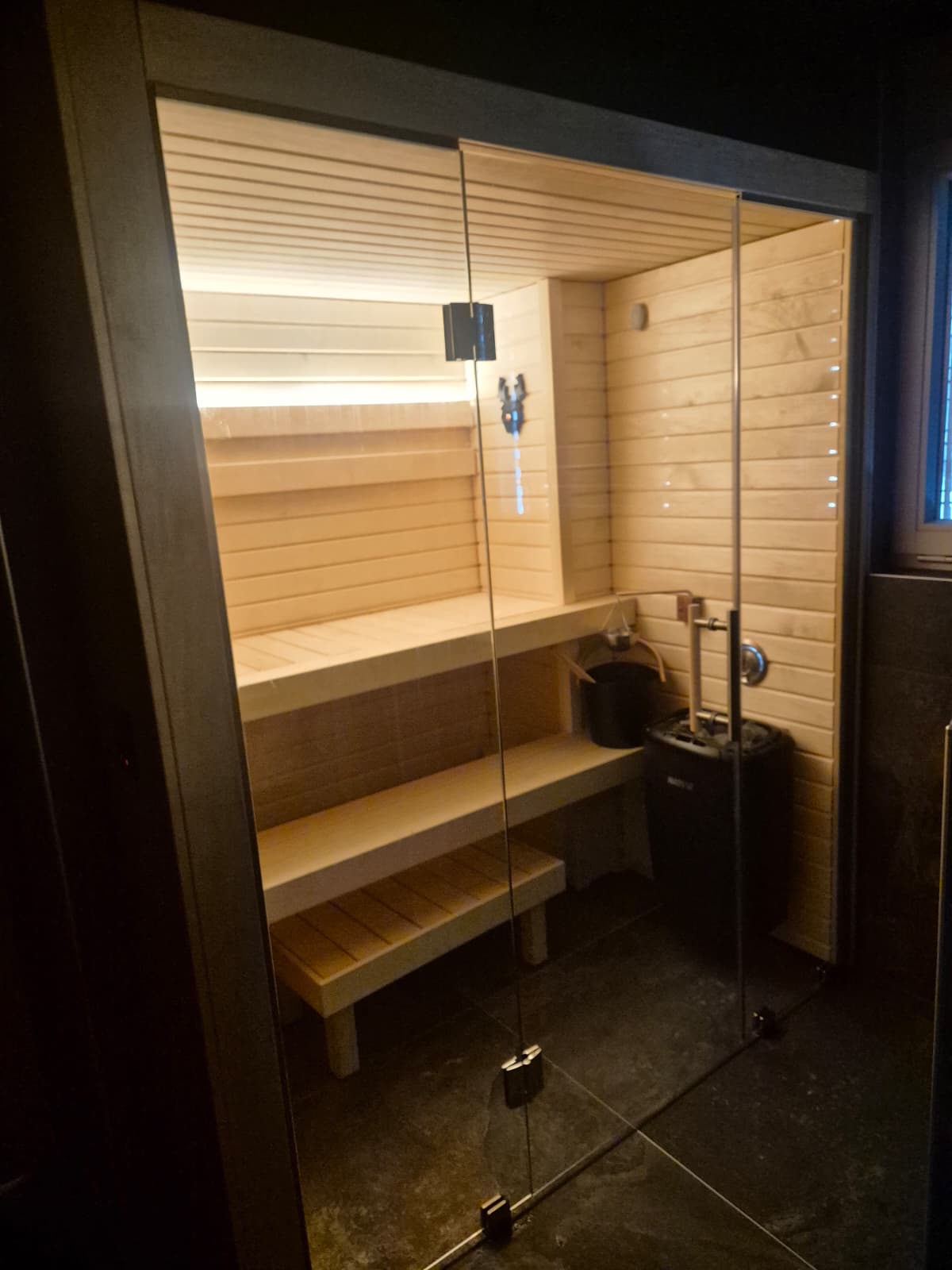 Intérieur de sauna en soirée, éclairage chaleureux au plafond