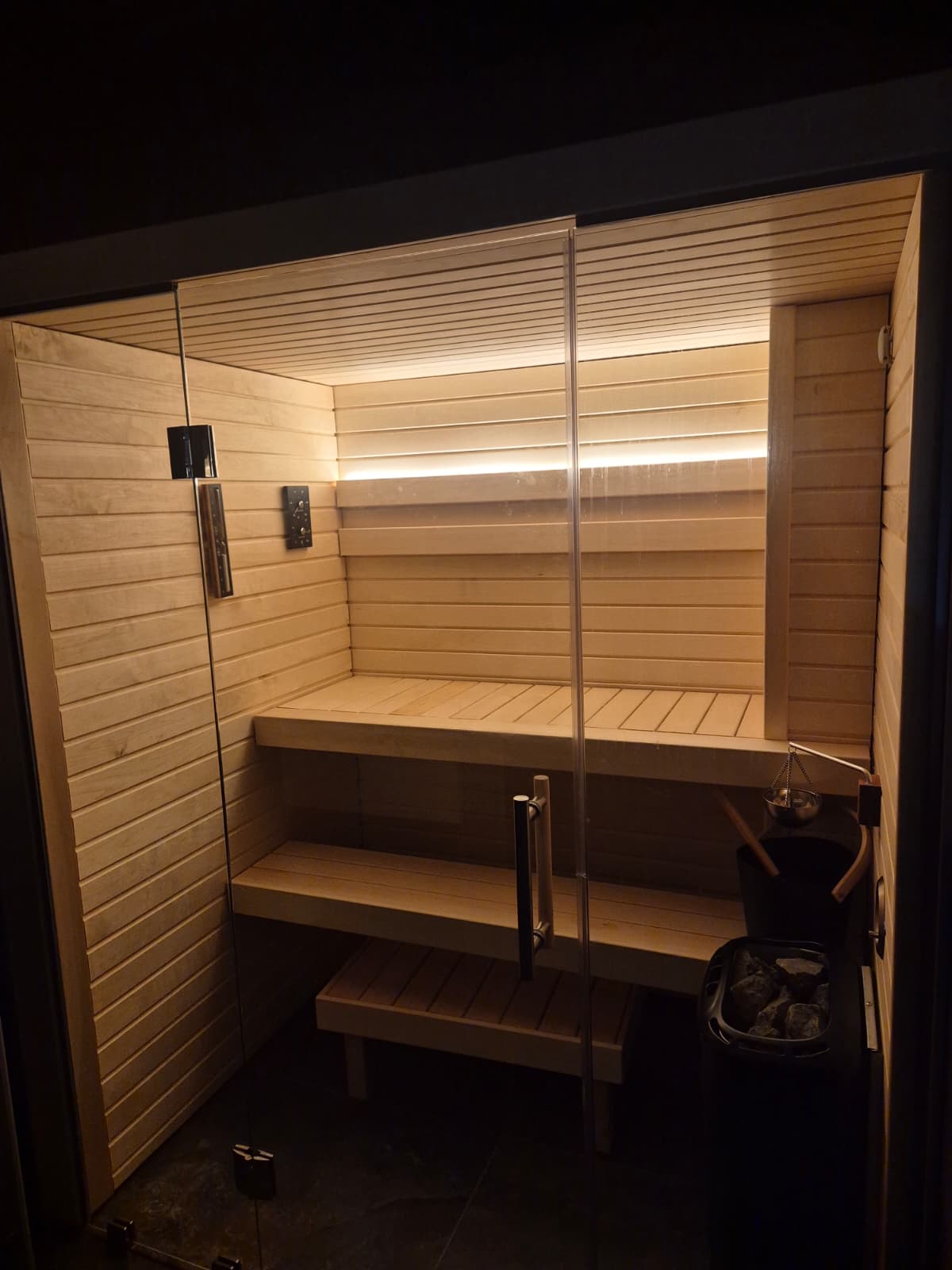 Bancs superposés et poêle d'un sauna, ambiance du soir